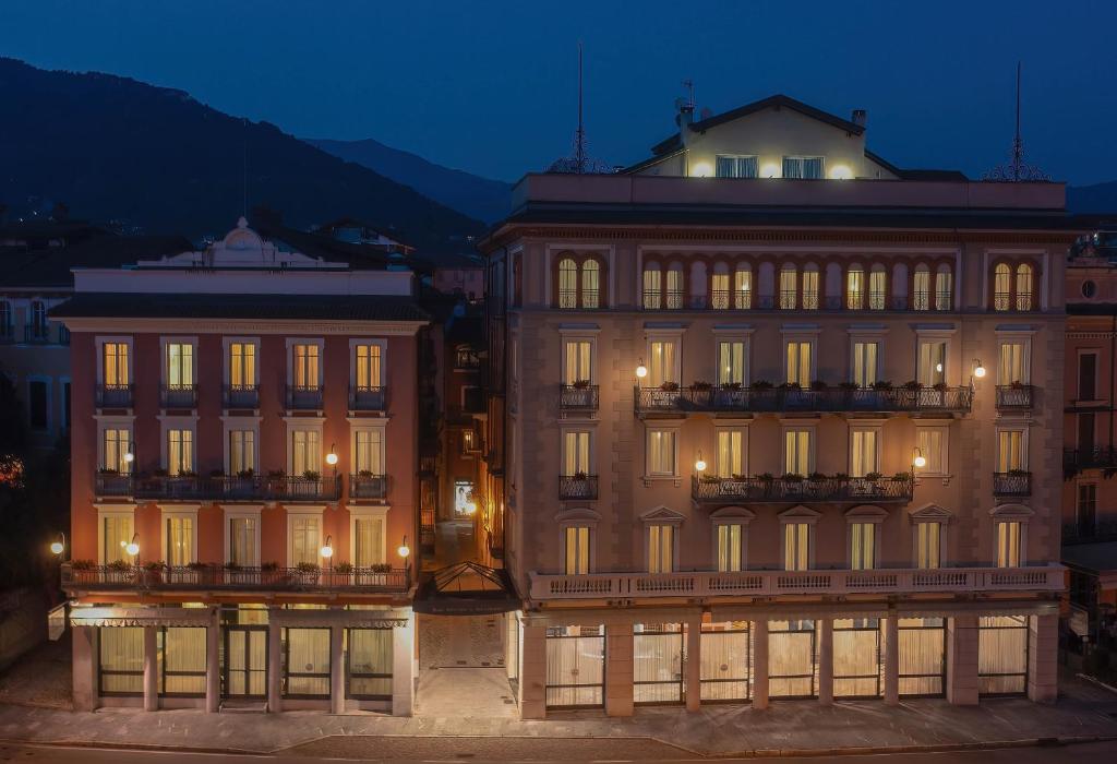 Hotel Belvedere San Gottardo by LVG Hotel Collection في فيربانيا: مبنى كبير في الليل مع إضاءة