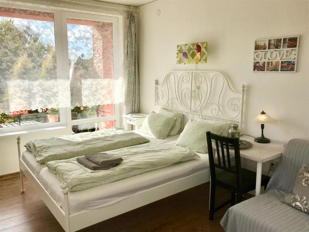 a bedroom with a bed and a table and window at Penzión Vilka Podhájčanka in Podhájska