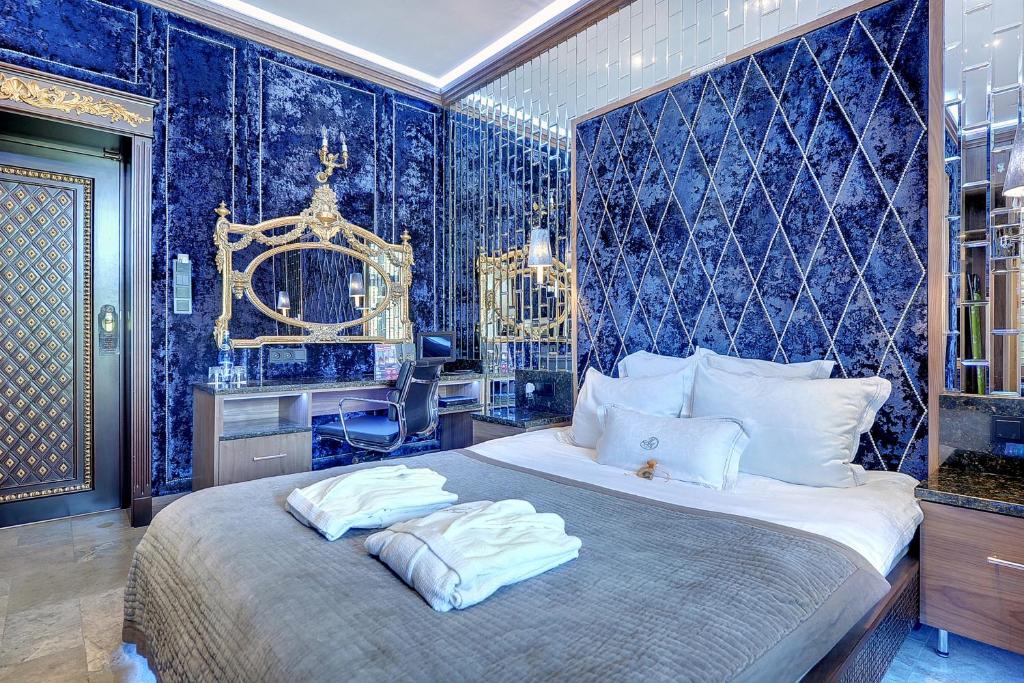 ein Schlafzimmer mit einem großen Bett mit blauer Tapete in der Unterkunft Mała Anglia Deluxe Rooms & SPA in Sopot