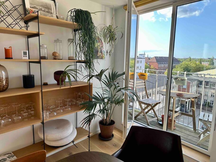 Cette chambre dispose d'étagères avec des plantes et d'un balcon. dans l'établissement Penthouse: Copenhagen delight, à Copenhague