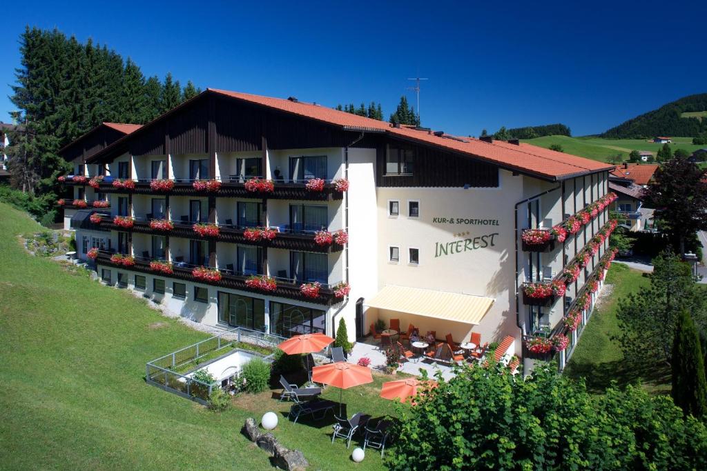 een luchtzicht op een hotel met tafels en parasols bij Interest Vitalhotel - Partnerbetrieb von Oberstaufen PLUS in Oberstaufen