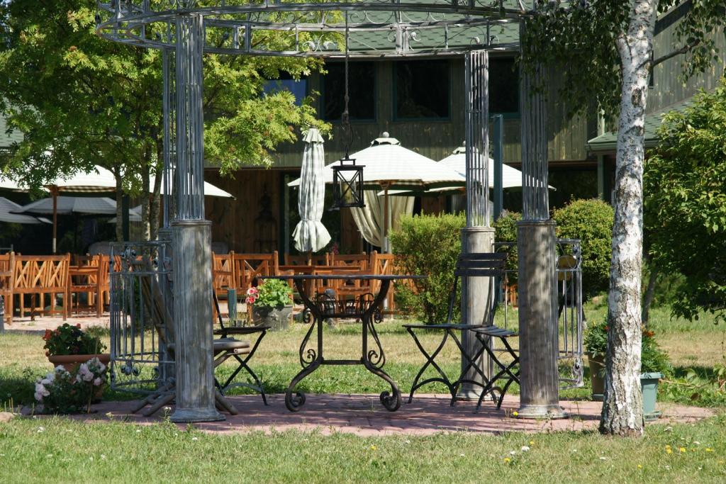 a patio with a table and chairs in a yard at Chill Inn in Bernāti