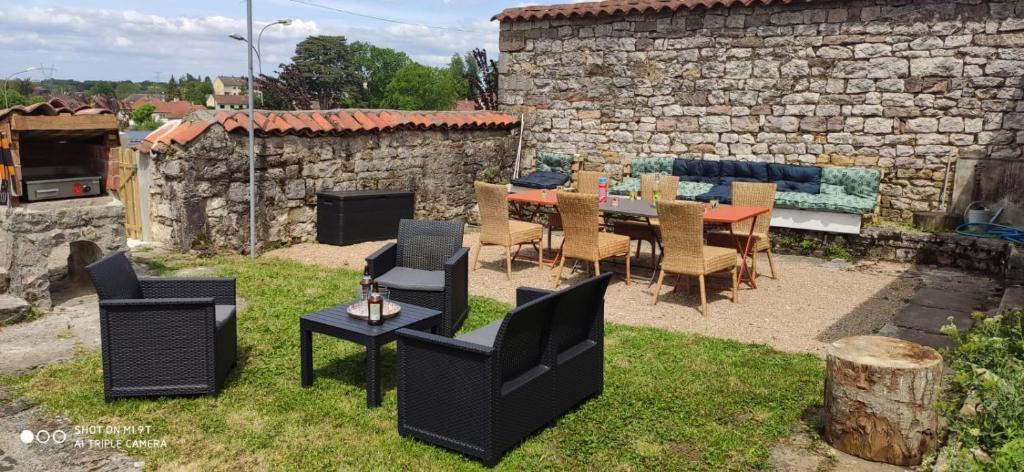 un patio con tavolo, sedie e camino di maison de charme avec jardin a Cousance