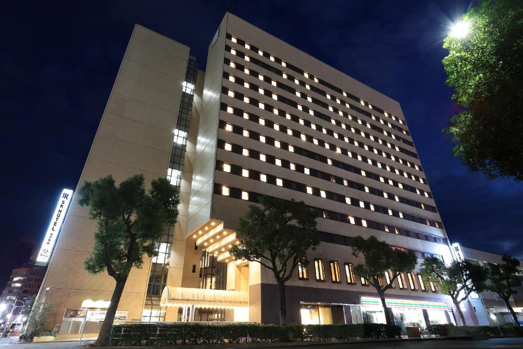 een groot gebouw met bomen ervoor bij SK HOTEL Kobe Ekimae in Kobe