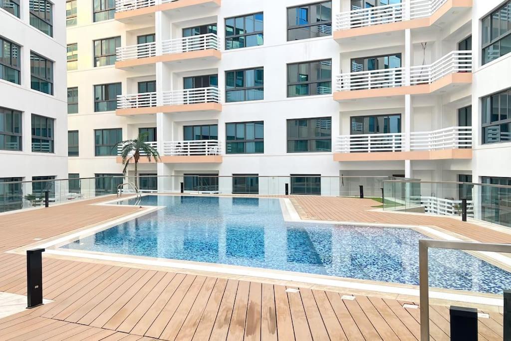 马斯喀特1BHK Near Airport, Pool, Parking的大楼前的游泳池