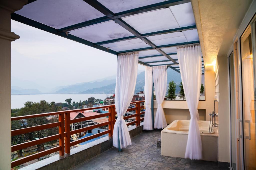 łazienka z wanną i balkon z widokiem w obiekcie Pokhara Alpine and Springs w mieście Pokhara