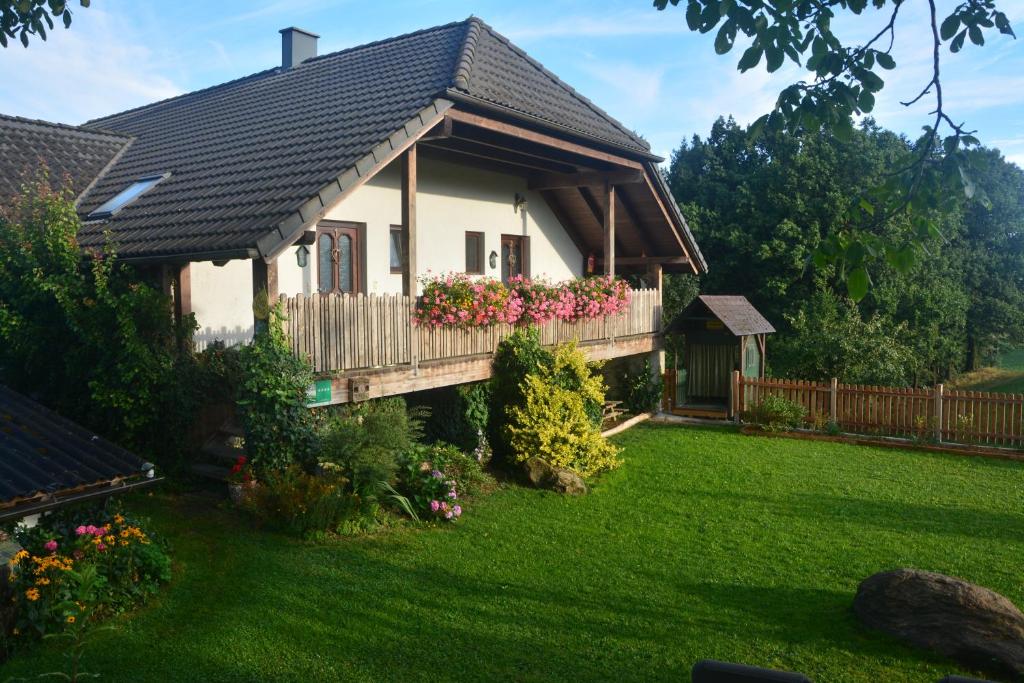 une maison avec un balcon fleuri dans la cour dans l'établissement Bio-Bauernhof Haunschmid, à Ardagger Markt