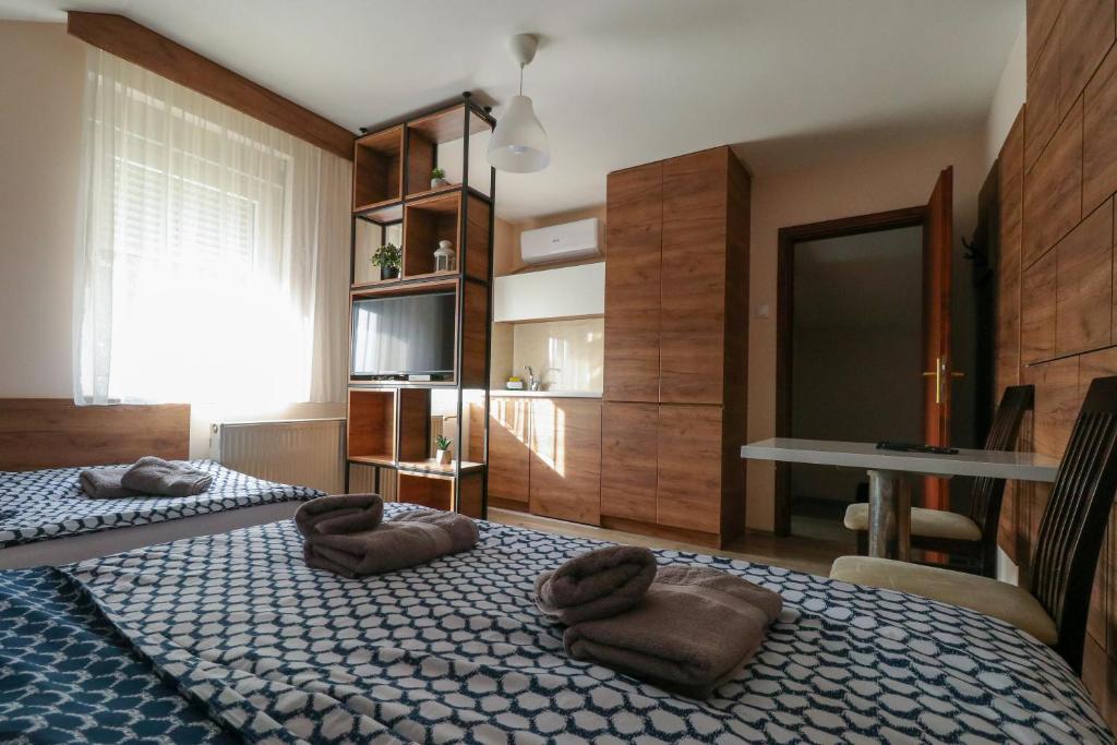 um quarto com 2 camas com almofadas castanhas em Studio Apartments Maksimović em Niš