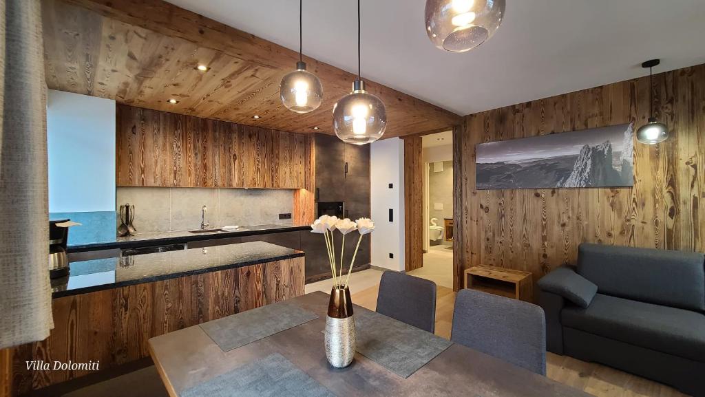 a kitchen and dining room with a table and a couch at Villa Dolomiti in Ortisei