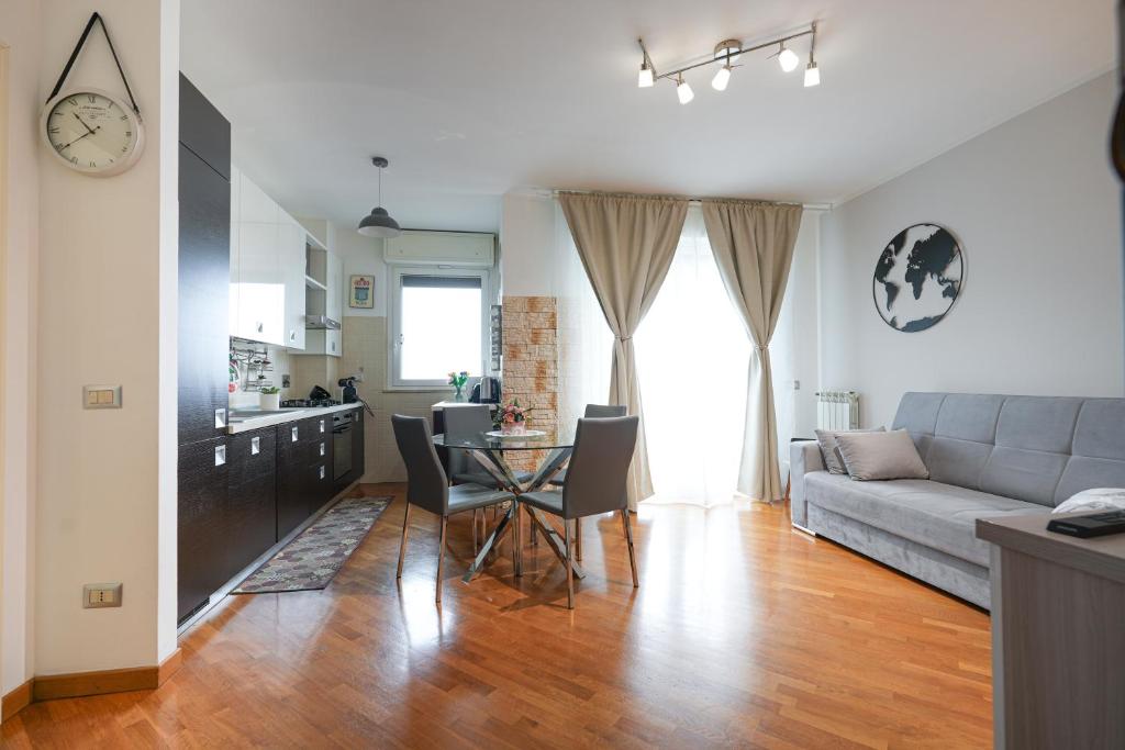 ein Wohnzimmer mit einem Sofa und einem Tisch in der Unterkunft Nuvola Apartment Fiumicino Easy Self check-in in Fiumicino