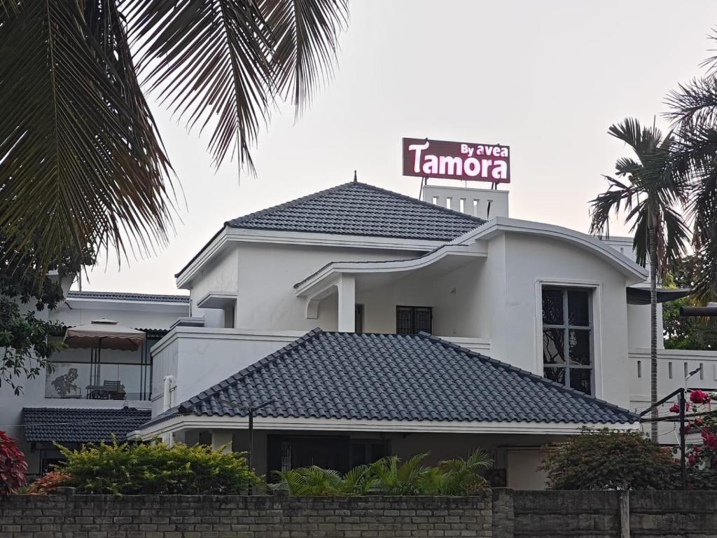 un edificio blanco con un cartel encima en Tamora By avea, en Madurai