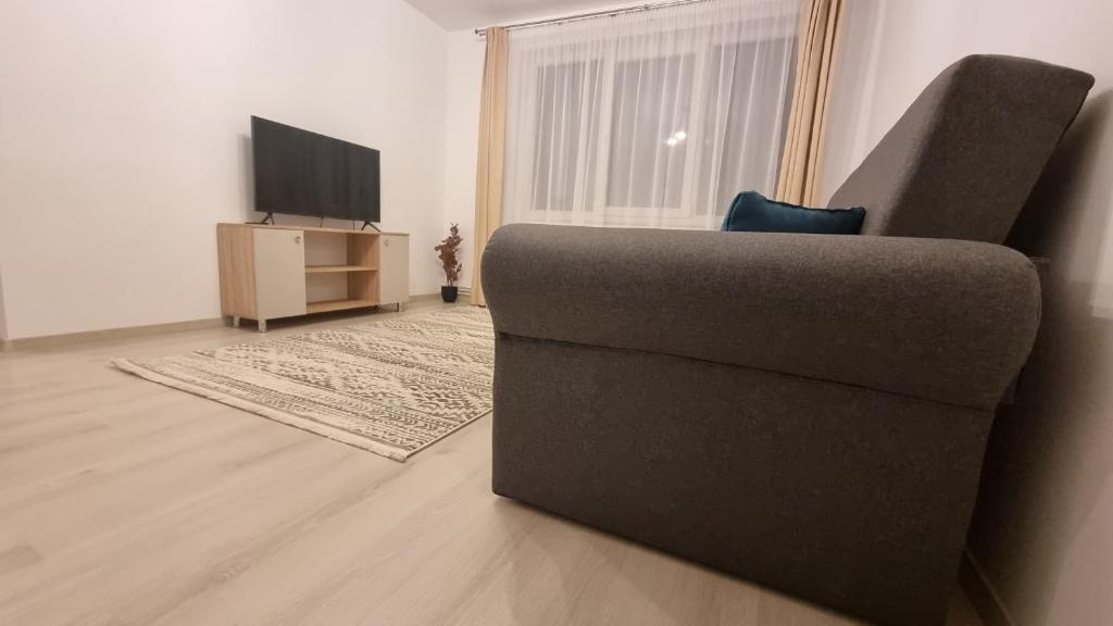 - un salon avec un canapé et une télévision dans l'établissement Comodo Apartment, à Turda