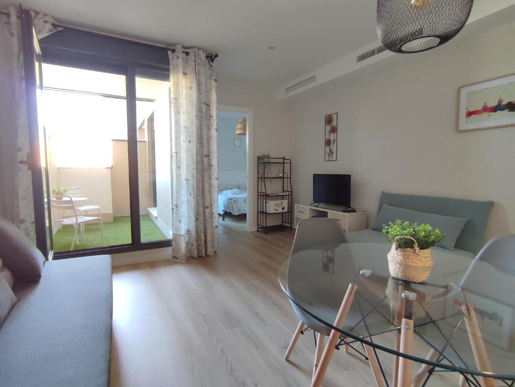 a living room with a couch and a table with chairs at Apartamento Servet, parking gratuito in Bormujos