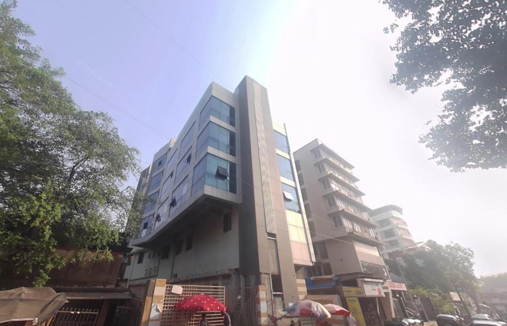 ムンバイにあるHotel Beverly Palace Santacruz - Near BKC - Mumbai Airport T1の通路脇の高層ビル