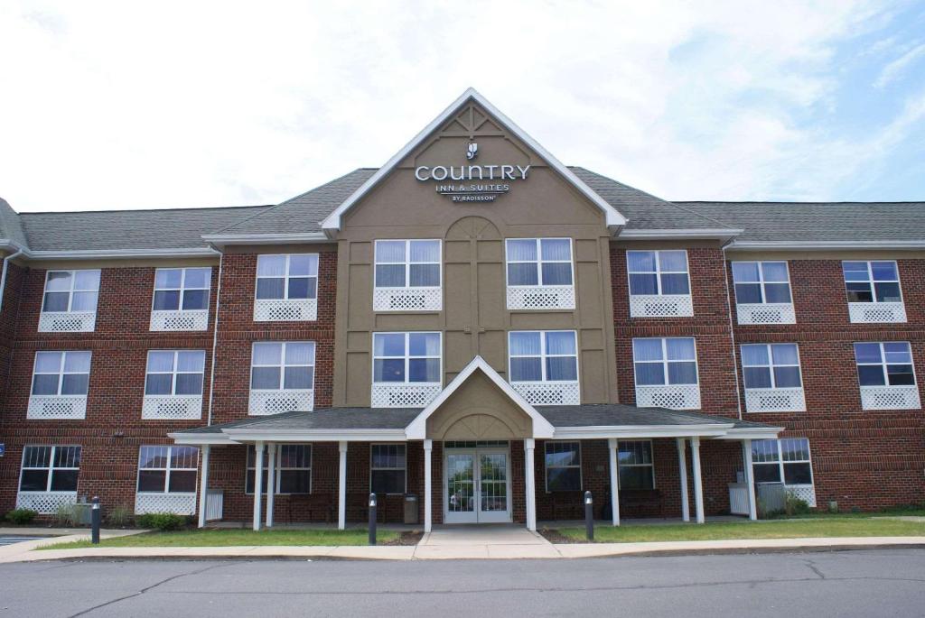 Country Inn & Suites by Radisson, Lansing, MI في لانسينغ: مبنى عليه لافتة مقاطعة