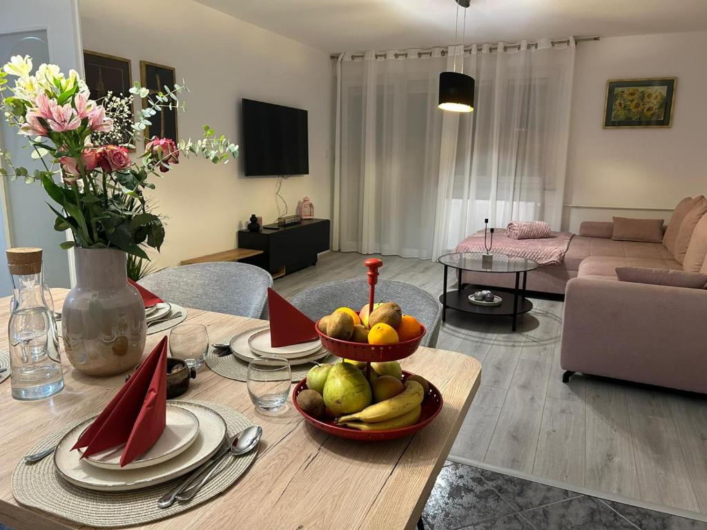 uma sala de estar com uma mesa com uma taça de fruta em Nastasija apartment em Osijek