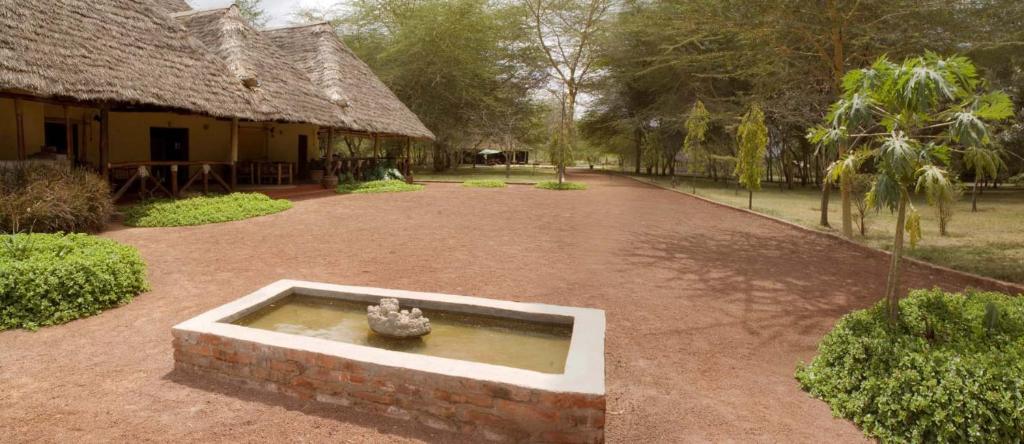 um pátio com uma fonte em frente a um edifício em NSYA CAMP MANYARA em Mto wa Mbu