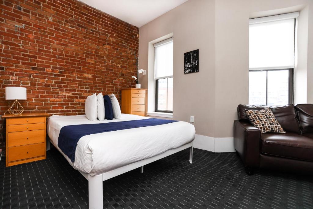 una camera con letto e muro di mattoni di Stylish Studio in Boston Brownstone, C.Ave #21 a Boston