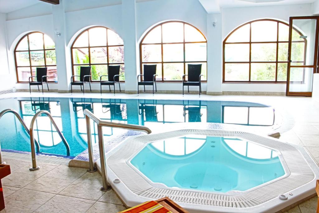 a large swimming pool with chairs and tables at Hotel Esprit in Braşov