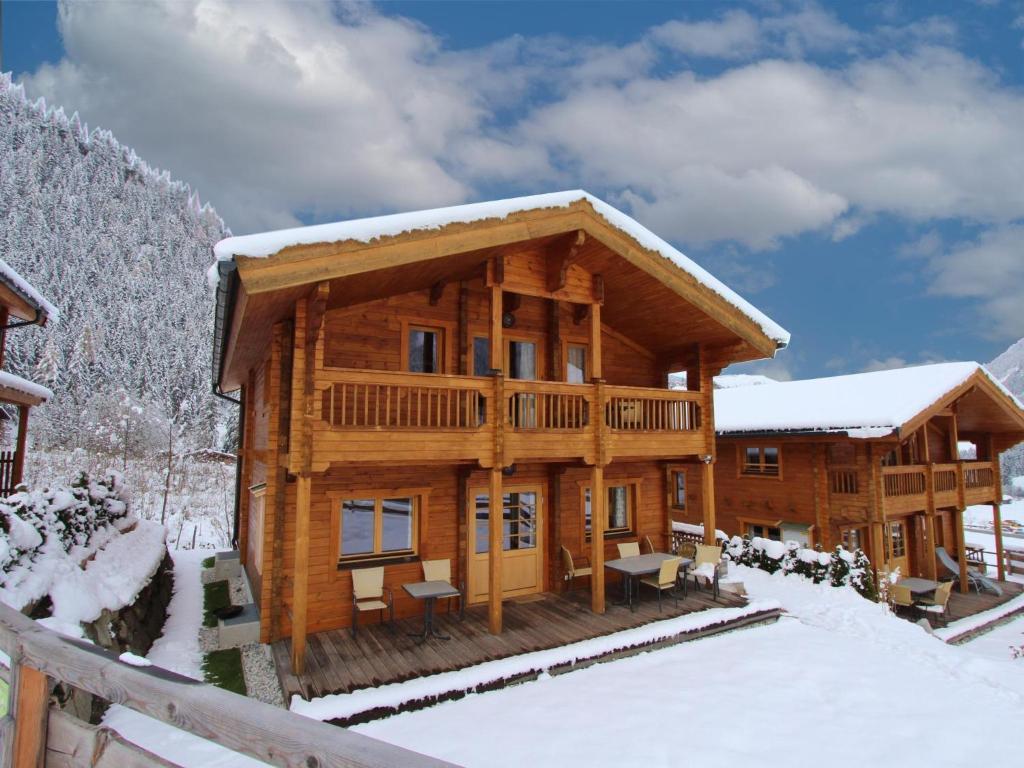 una cabaña de madera en la nieve con nieve en Waldberg, en Krimml