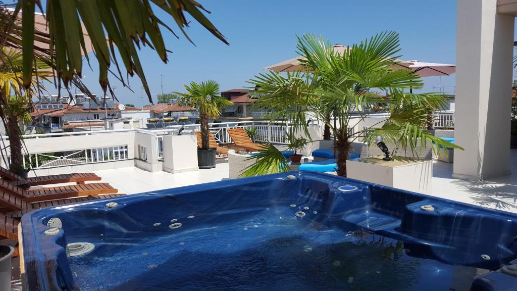 d'une baignoire bleue sur un balcon avec des palmiers. dans l'établissement Harisis Apartments, à Olympiakí Aktí