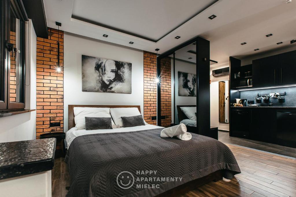 a bedroom with a bed and a brick wall at Happy Night - ApartamentyHappy pl in Mielec