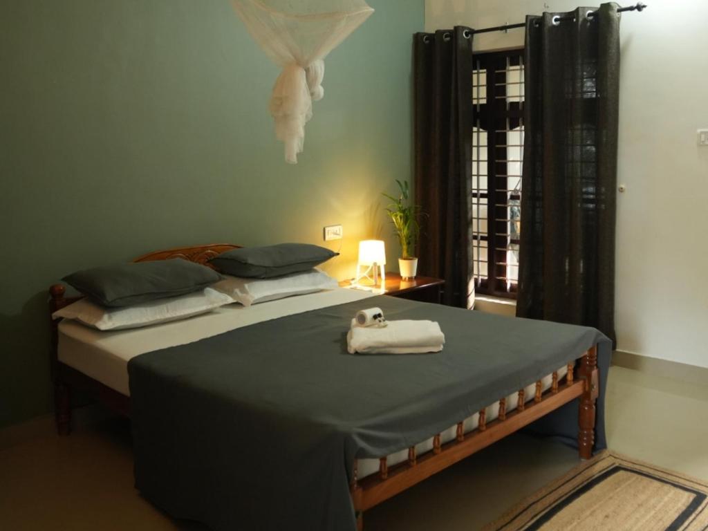 ein Schlafzimmer mit einem Bett und einem Handtuch darauf in der Unterkunft Mad about Coco Yoga & Beach Retreat in Varkala