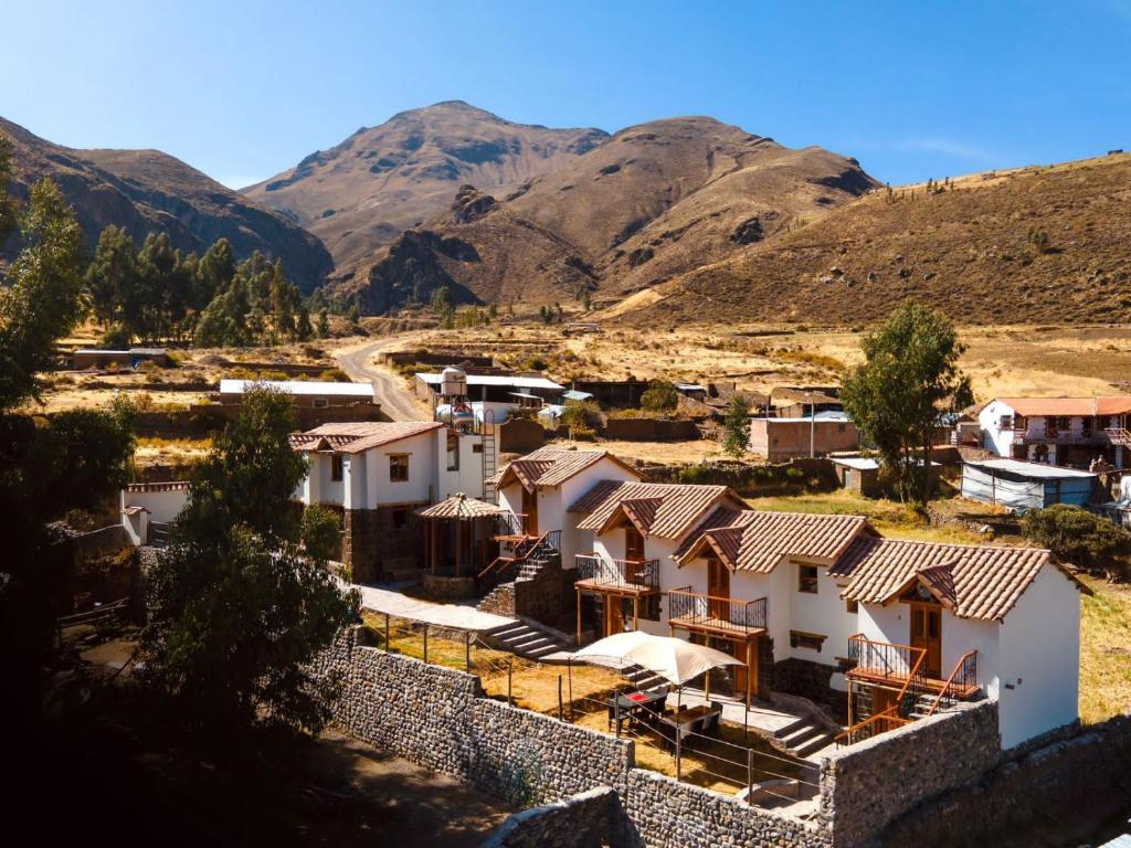 uma vista para uma aldeia nas montanhas em Lodge El Portal de Qopuy em Coporaque