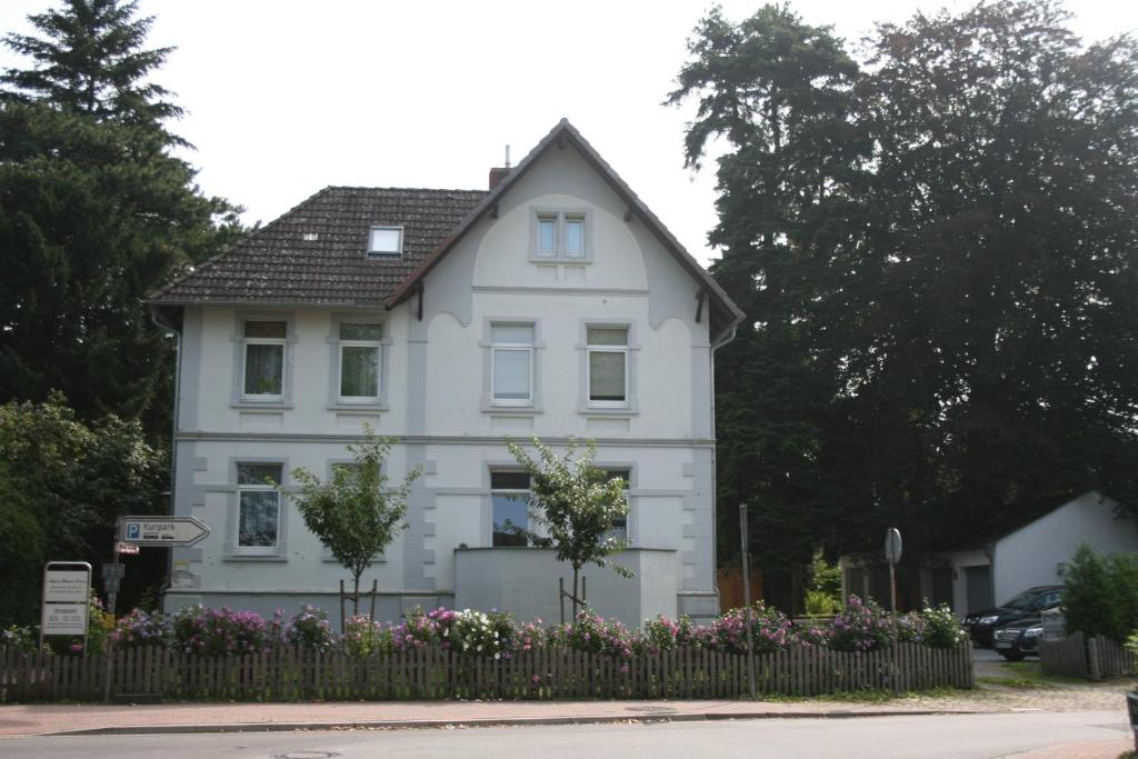 une maison blanche avec une clôture devant elle dans l'établissement Ferienwohnung am Kurpark, à Bad Nenndorf