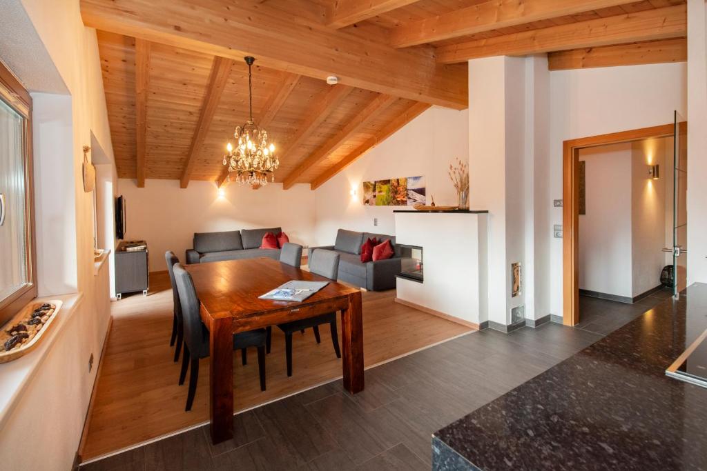 comedor y sala de estar con techo de madera en Natural Deluxe Apartments Alpbach, en Alpbach