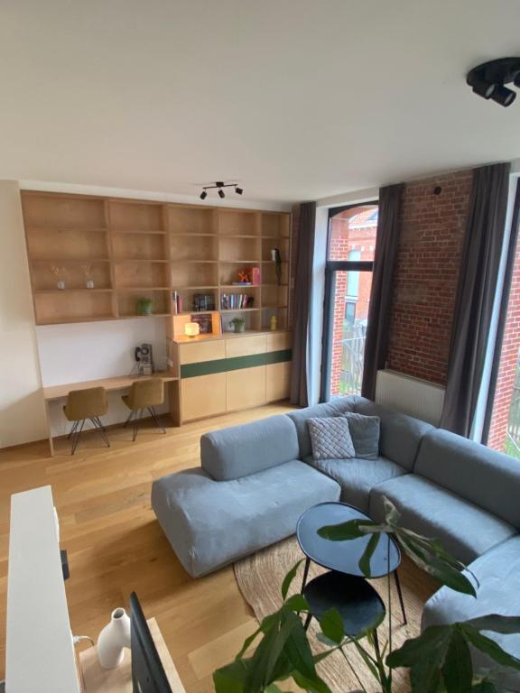 a living room with a blue couch and a table at Woning Oostende - Oosteroever in Ostend