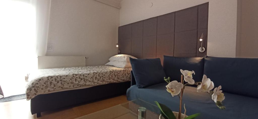 een slaapkamer met een bed en een bank met witte bloemen bij Studio apartmani OK Lipik in Lipik