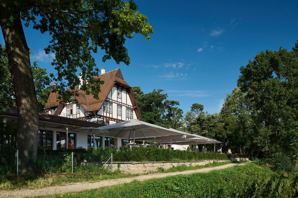 een groot wit huis met een dak bij Boutique Hotel Waldhaus beider Basel in Bazel