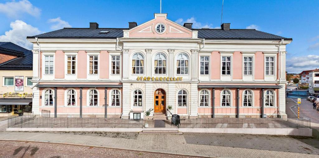 um grande edifício rosa e branco numa rua em Vimmerby Stadshotell, WorldHotels Crafted em Vimmerby