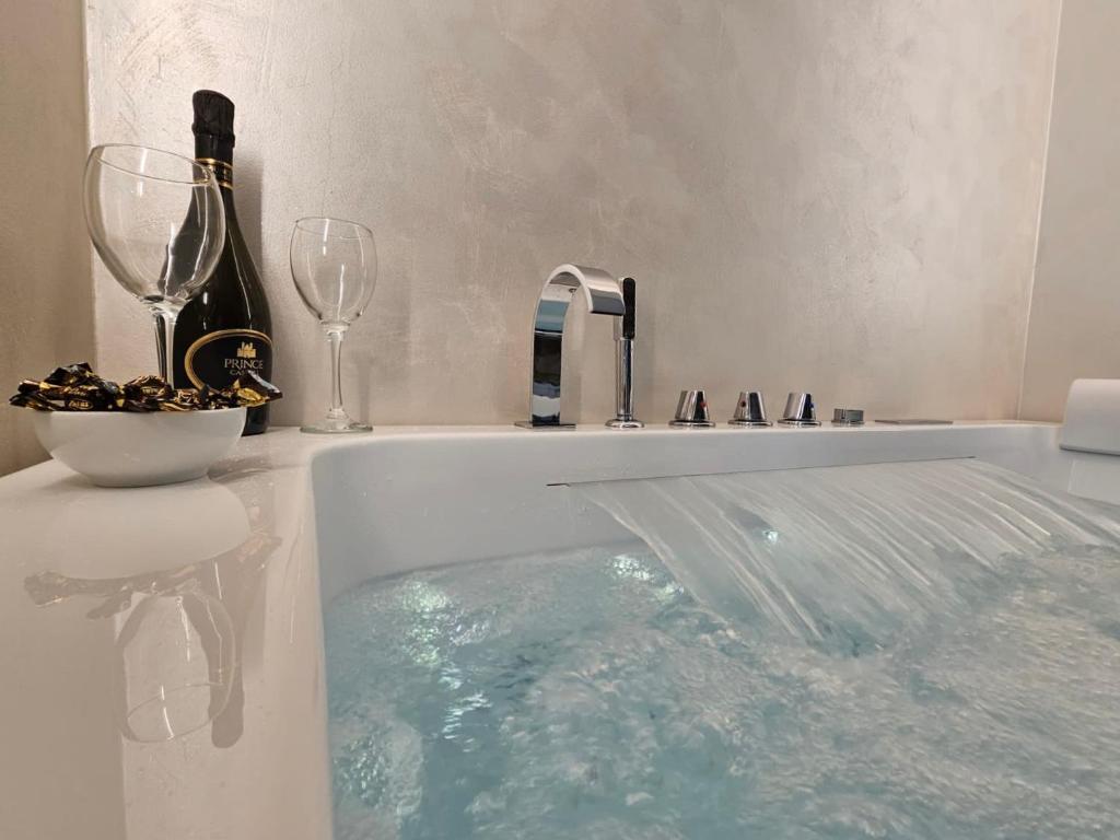 een bad met een fles wijn en een glas bij Il Tiglio Jacuzzi&Sauna in Lucca