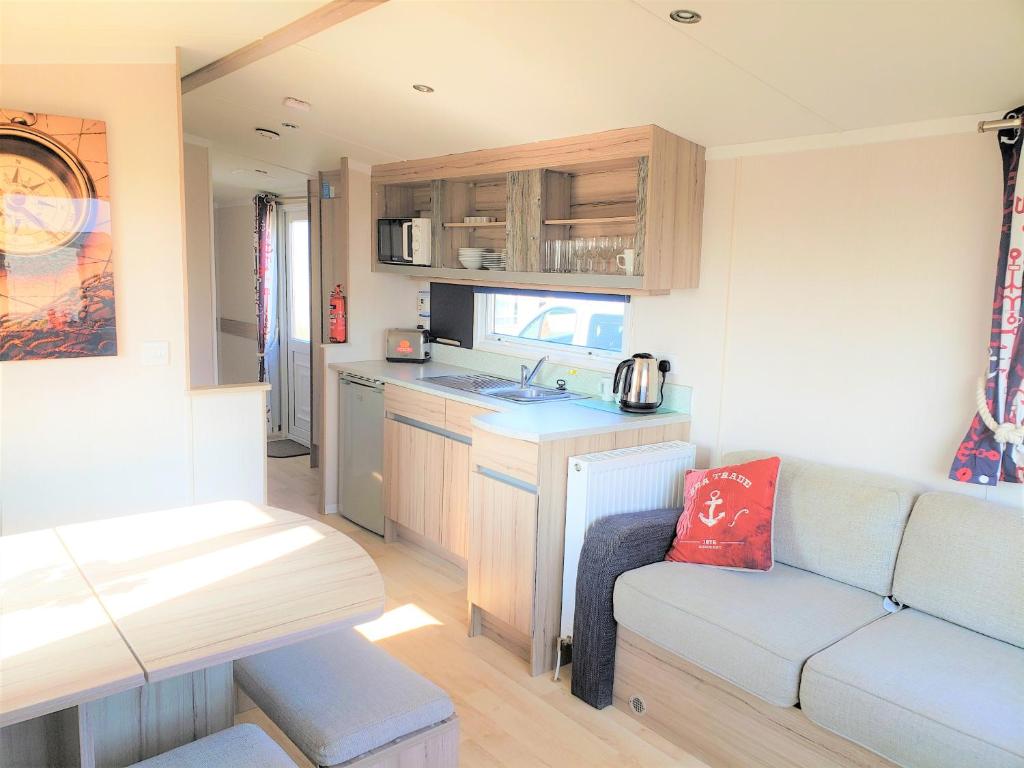 Caravana con sala de estar con sofá y cocina. en Sea Break, Perran Sands, Perranporth, en Perranporth