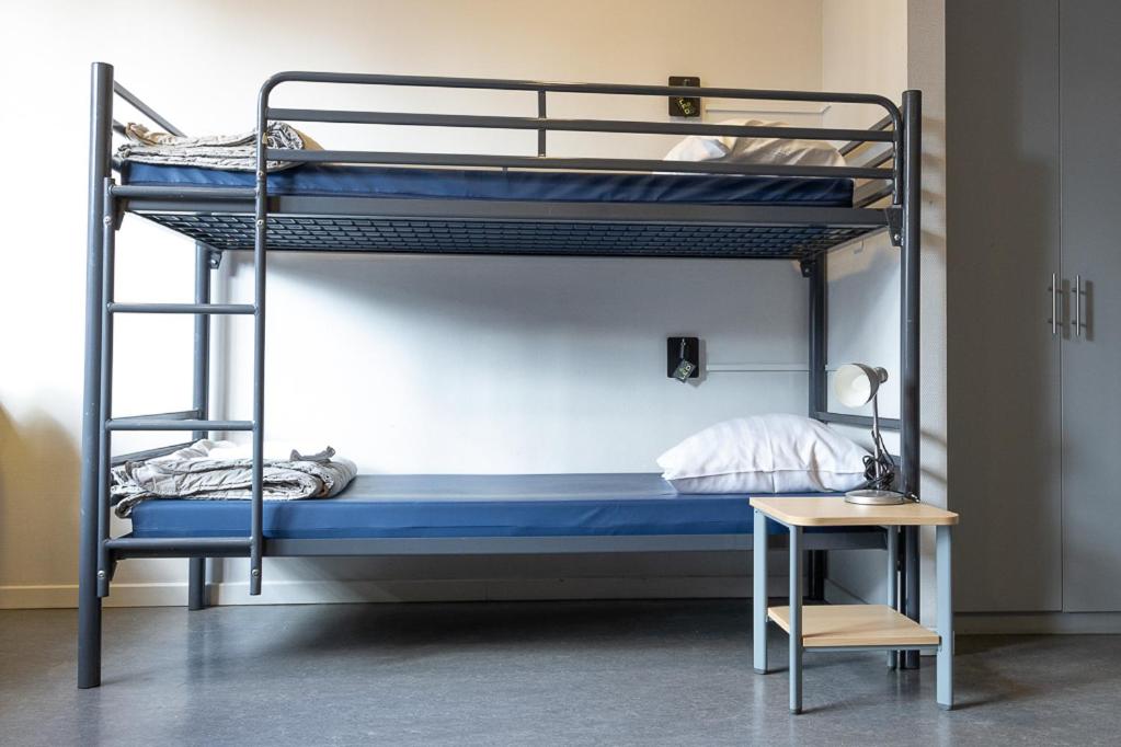 a bedroom with two bunk beds and a table at Hostel Van Gogh in Brussels