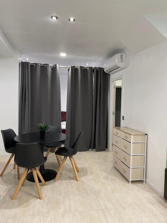 a room with black curtains and a table and chairs at STUDIO ROSES PLAGE in Roses