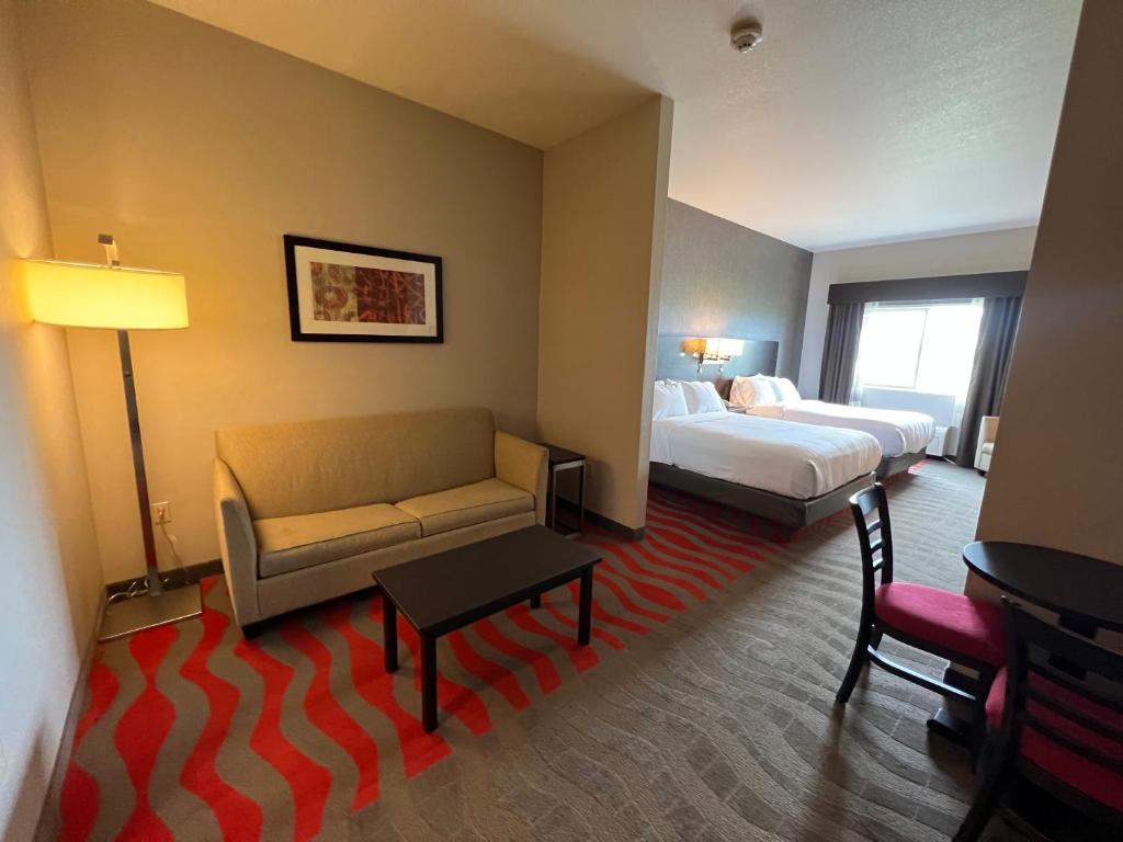 une chambre d'hôtel avec un canapé et un lit dans l'établissement Comfort Suites Boise West Meridian, à Meridian