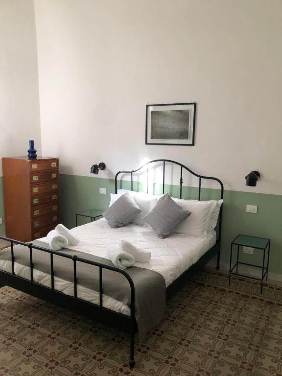 een slaapkamer met een bed met witte lakens en kussens bij Caves Apartment in Bari