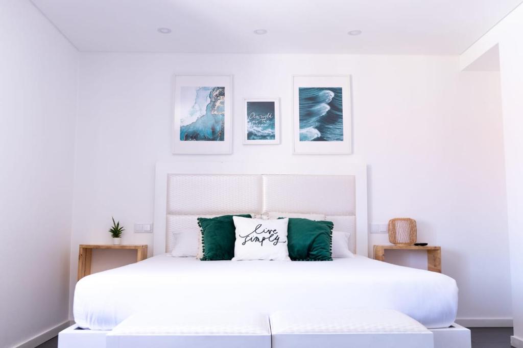 - une chambre blanche avec un lit blanc aux accents verts dans l'établissement SUPERTUBOS HOUSE Peniche, à Peniche