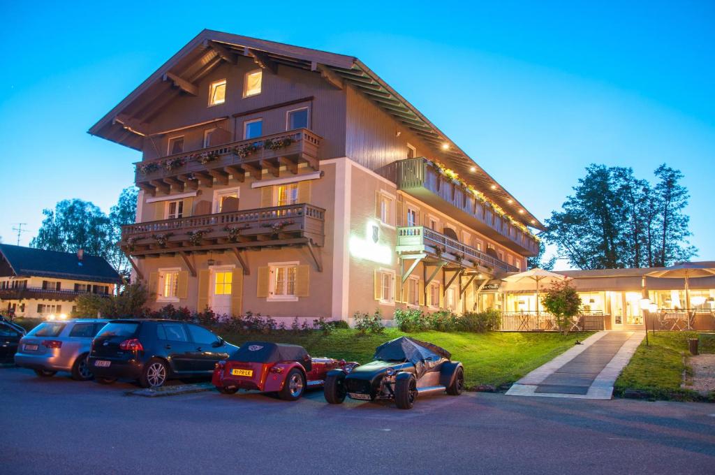 Hotel Schlossblick Chiemsee في برين أم كيمزيه: مبنى كبير فيه سيارات تقف امامه