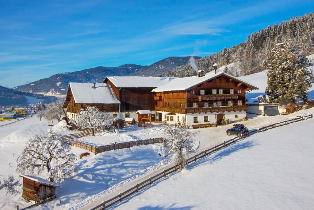 a large wooden building in the snow with snow at Nöglhof in Radstadt