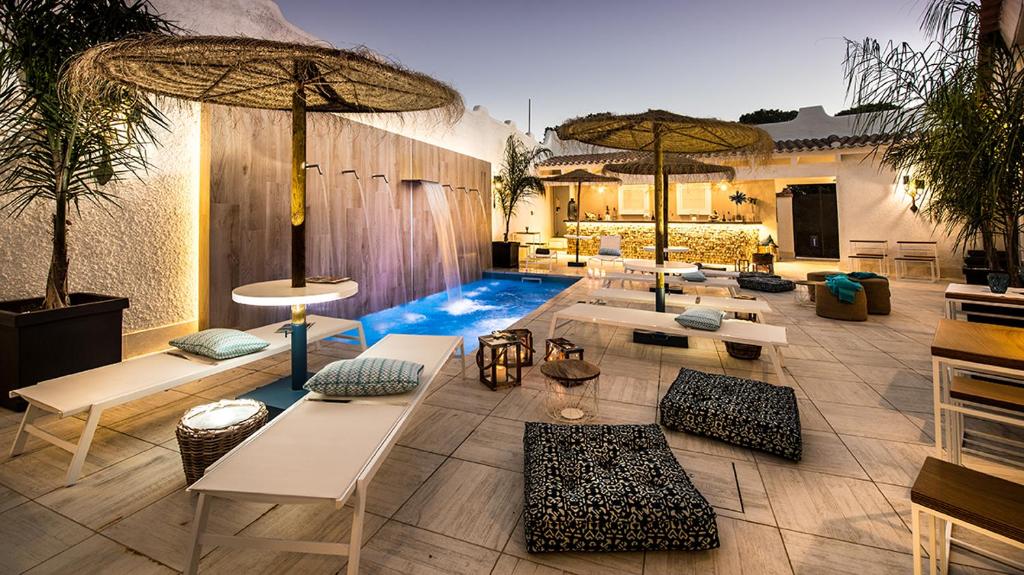 a pool with tables and chairs and umbrellas at CapoBlu Hotel in Pula