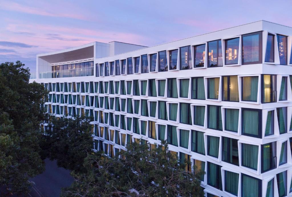 ein hohes weißes Gebäude mit vielen Fenstern am Abend in der Unterkunft ATLANTIC Hotel Münster in Münster