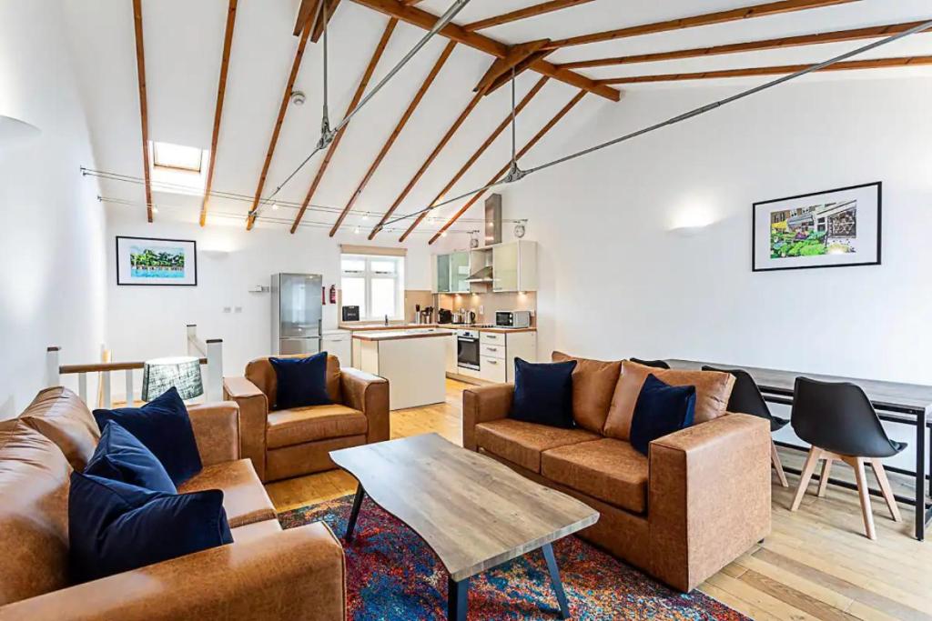 a living room with couches and a table at Light and airy upside down house in Hackney in London