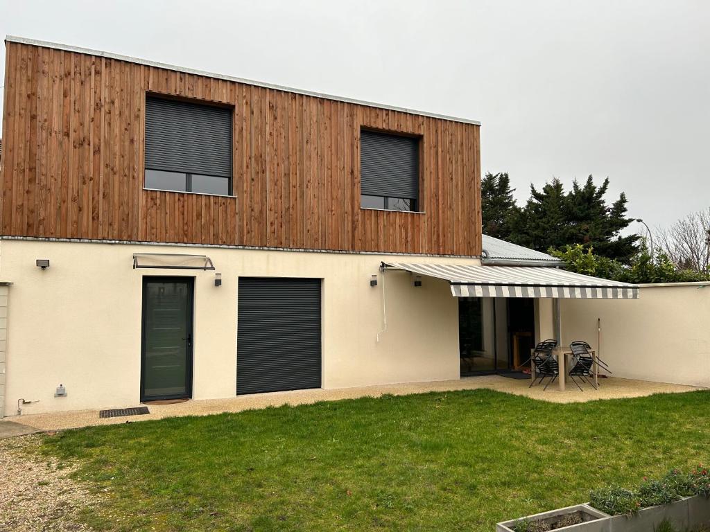 a white house with a wooden wall at Sara in Aulnay-sous-Bois