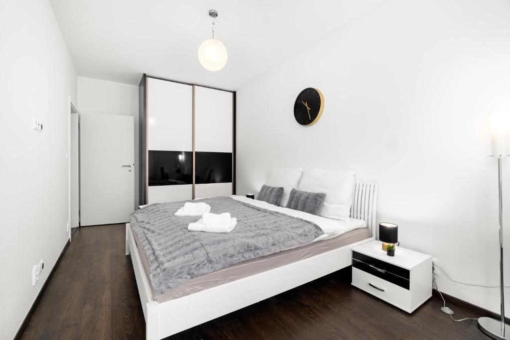 BNB New Beautiful Apartment in the Center of Ostrava with option Garage Parking في Moravská Ostrava: غرفة نوم بيضاء مع سرير كبير ومرآة