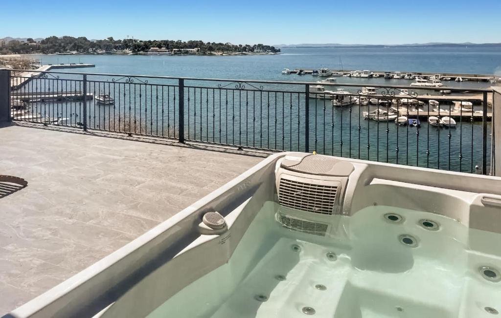 eine Badewanne auf einem Balkon mit Blick auf das Wasser in der Unterkunft Gorgeous Apartment In Petrcane With Kitchen in Petrcane