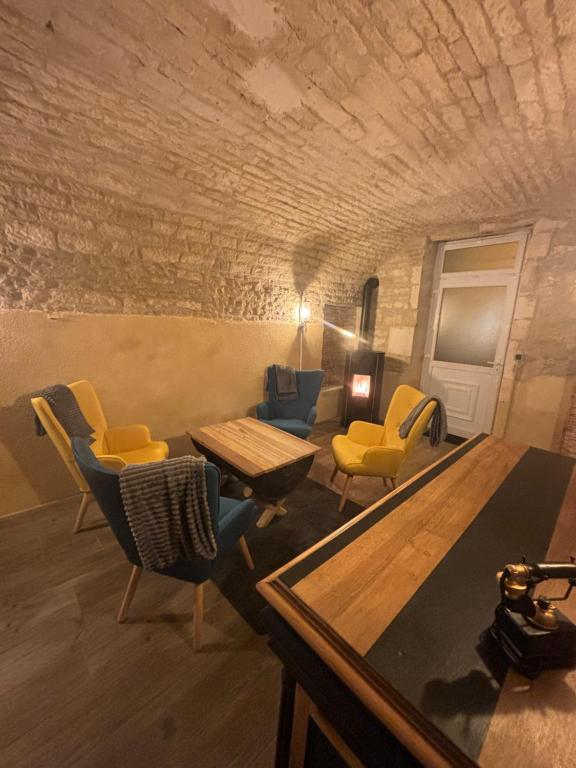 uma sala de estar com cadeiras amarelas e uma mesa em La maison de pierres em Chablis